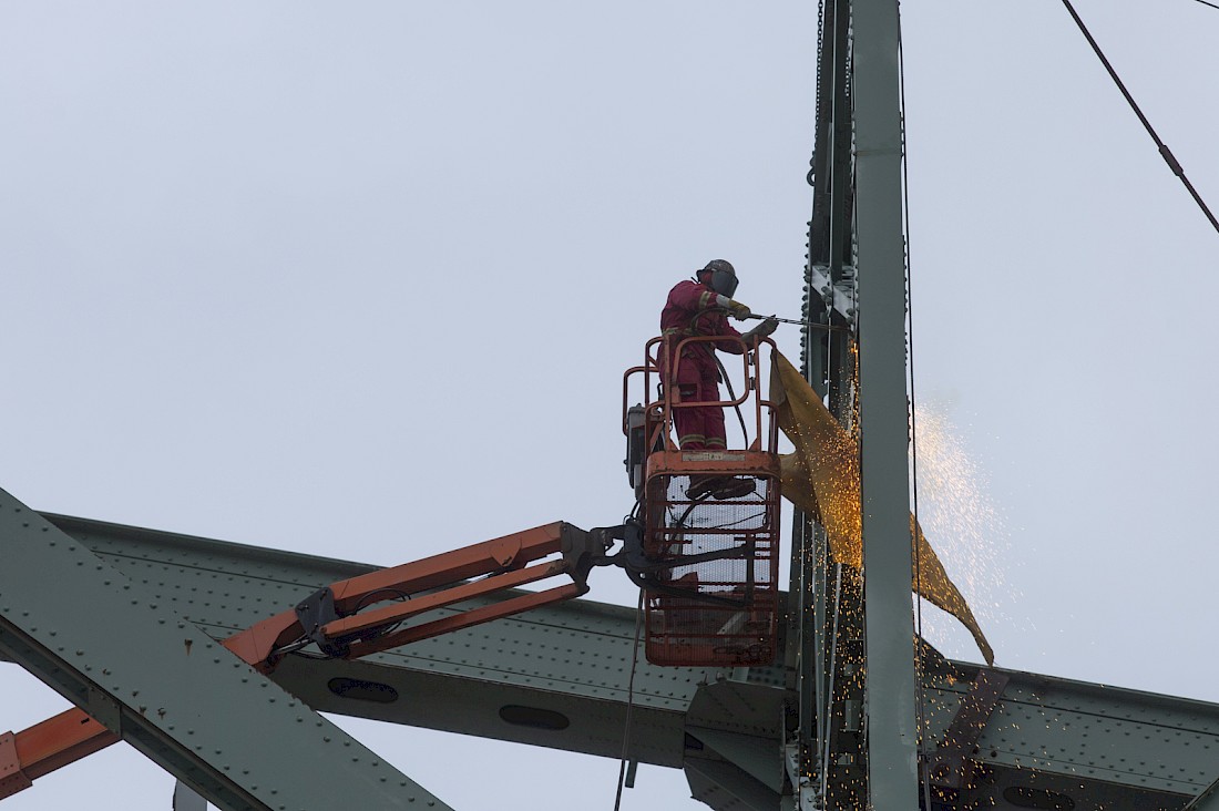 Un monteur d’acier découpe une pièce avant sa descente sur la jetée.