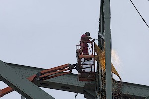 Un monteur d’acier découpe une pièce avant sa descente sur la jetée.